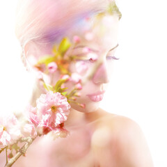 Beautiful young female face with spring blooming cherry tree flowers, double exposure. Beauty treatment, youth, springtime concept