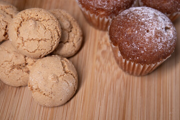 muffins, almond amaretti and oat cookies on wooden stand board. sweet bakery concept