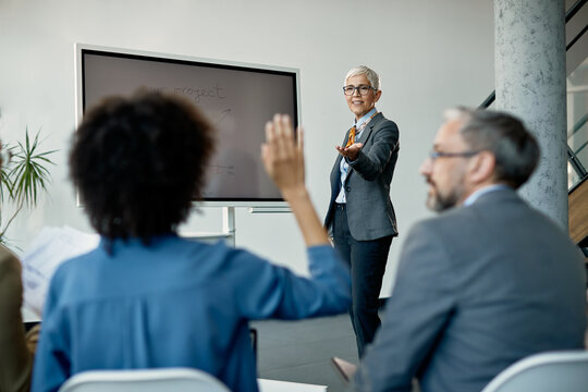 Happy Mature Business Leader Asking Question While Giving Presentation To Her Team In The Office.