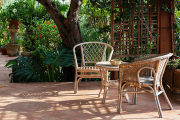 Terrace with comfortable wicker furniture, villa in garden, Sicily, Italy