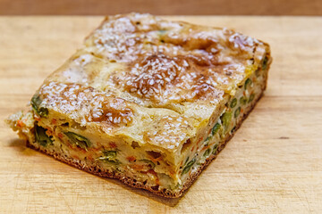 homemade pie with vegetables and green beans on a wooden cutting board