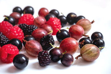 Assorted berries of raspberries, gooseberries, currants on a white plate