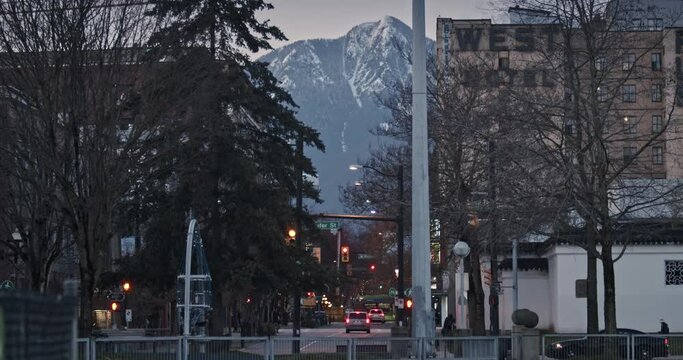 Downtown City Lights with Mountain Snow in Background at Sunset Dusk Night in Vancouver Canada