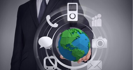 Composition of network of digital icons with globe over hand of businessman