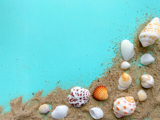 Colorful bright summer beach composition.  Seashells, sand, sea pebbles on a blue background.  Top view, flat lay, copy space.  Summer beach vacation concept.