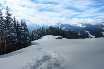 Fototapeta na wymiar Schneespur zur Almhütte in den Bergen