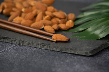 Minimalism concept of almond and meal sticks on dark background. 