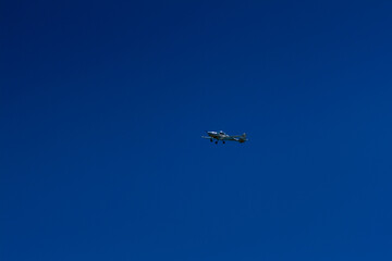 The plane flies in the blue sky