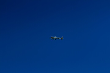 The plane flies in the blue sky