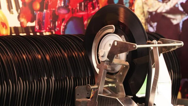 Great shot Jukebox start playing music from vinyl single record with old time classic mechanism.   