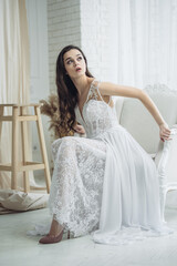 Bride in beautiful dress sitting on a vintage chair. On The Morning Of The Bride. Fine art wedding.