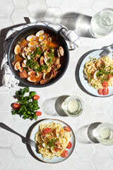 Mediterranean cuisine: pasta with seafood, with vongole. Italian lunch. Lifestal mood. Light background, top view