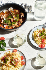 Mediterranean cuisine: pasta with seafood, with vongole. Italian lunch. Lifestal mood. Light background, top view