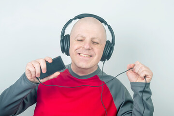 man with headphones listening to music through a digital portable player