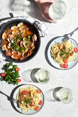 Mediterranean cuisine: pasta with seafood, with vongole. Italian lunch. Lifestal mood. Light background, top view