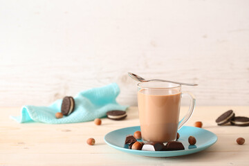 Cup of cocoa and nuts on a white wooden background with place for text