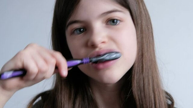 Little beautiful girl brushes her teeth with a toothbrush and toothpaste