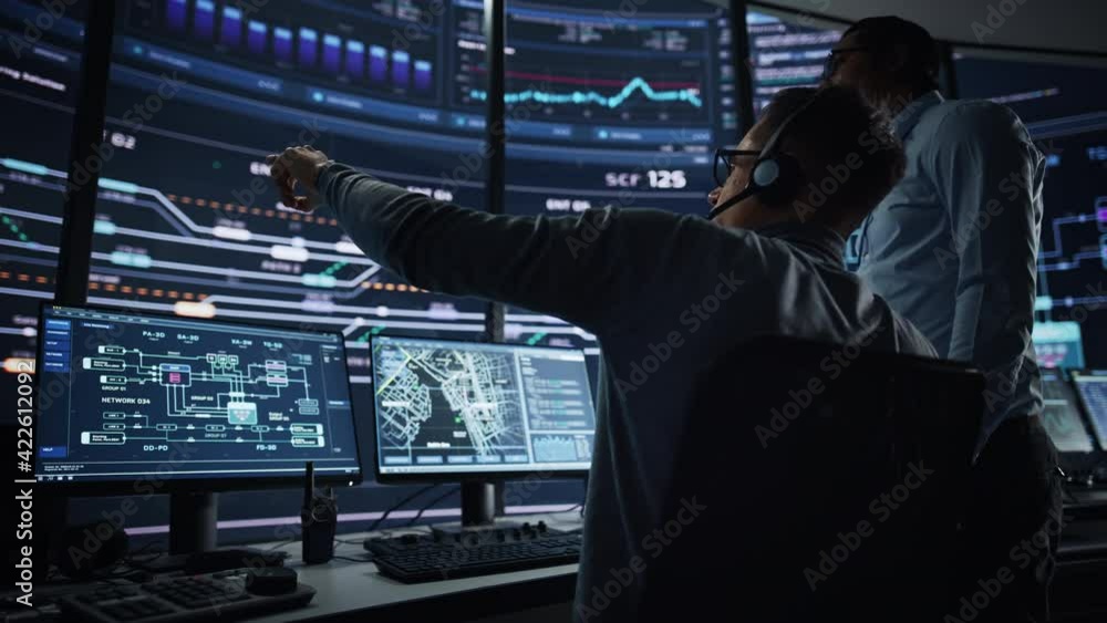 Leinwandbilder In the System Control Room Project Manager and IT Technical Engineer Have Discussion, they're surrounded by Multiple Monitors with Graphics. Big Monitor Shows Interactive Server Blockchain Info.