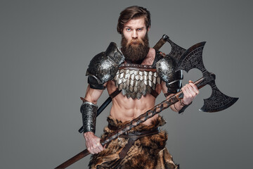 Handsome antique viking warrior with an axe in gray background