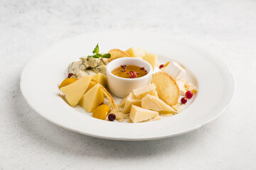  assortment of different cheeses with honey as an appetizer