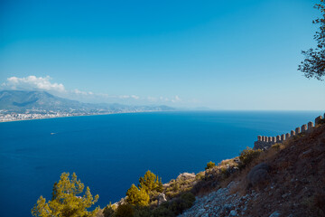 Fototapeta na wymiar Sunny sea panorama landscape of Alanya Castle in Antalya district, Turkey. Popular tourist destination with high mountains. Summer sunny day and beautiful sea background