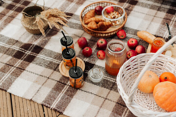 autumn picnic close-up pumpkin red apples jam on a plaid blanket