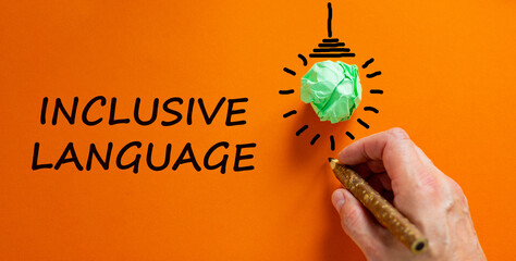 Inclusive language symbol. Businessman writing words 'inclusive language', isolated on orange...