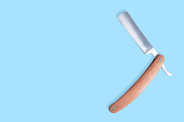 Straight metal razor with a wooden handle.