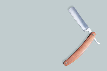 Straight metal razor with a wooden handle.
