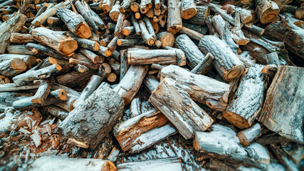 chopped firewood piled in a heap and covered with snow