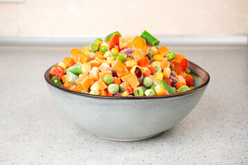 Assorted frozen vegetables in a plate. Semi-finished vegetable mix for instant cooking. Food concept.