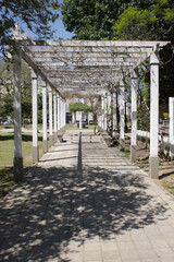 Beautiful path with white wood columns and plants in a park