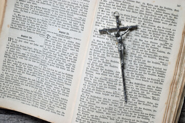 Kruzifix auf aufgeschlagener alter Bibel