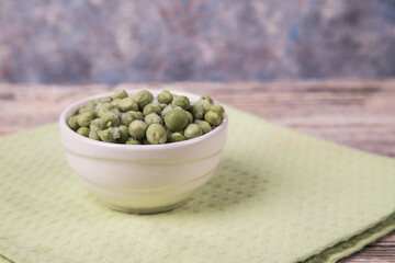 Frozen peas in a light plate on a light green napkin. Frozen Food Concept