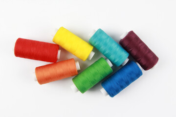 Colored, rainbow threads for sewing with a needle. Handmade concept, clothing repair. Top view. Flatley. Copyspace.