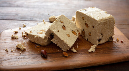 Halva almond nuts slices on wooden table background