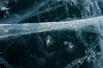 white cracks in transparent ice on the lake