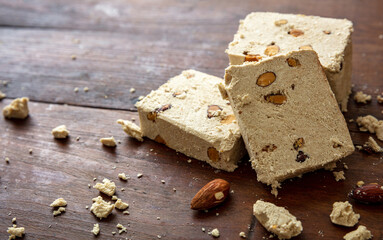 Halva almond nuts slices on wooden table background