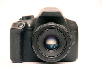Digital single-lens reflex camera camera without logo with 50 mm 1.8 aperture prime lens without hood. Front view studio shoot on white background
