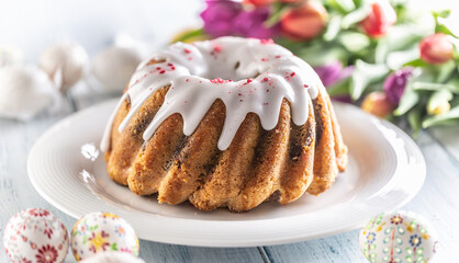Festive easter marble cake with icing sugar hand-decorated eggs and spring tulips