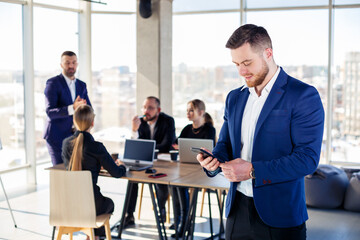Business people, businessmen are working together in a modern office in a multi-storey skyscraper. The director is on the phone. Office work concept. Selective focus