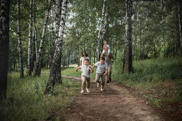 Two elder boys are running a race, their parents and younger brother are cheering for them. Image...