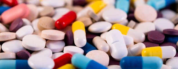 A handful of multi-colored pills. Medicines for colds, coronavirus, flu. Lots of drugs.