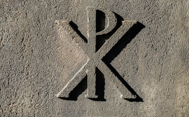 XP - sign, symbol of christianity - chrism. jesus christ. on gray stone texture.