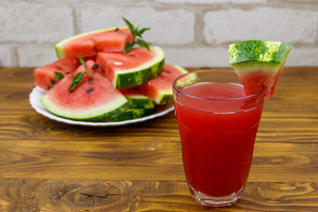 Glass of fresh watermelon juice on a wooden table