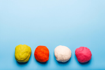 Homemade plasticine, plasticine, play dough on a colored background. Molding clay