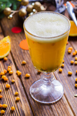 the hot yellow drink with sea-buckthorn berries in a glass
