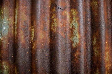 Damaged galvanized iron sheet wall on old warehouse. Detail view of old rusty corrugated metal sheet.