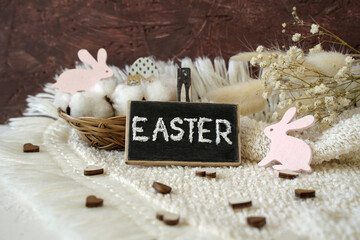 decoration for easter. inscription Easter, a basket with eggs and pink rabbits