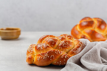 Delicious rose braid bread with sesame seeds. Homemade. Light grey background, copy space.